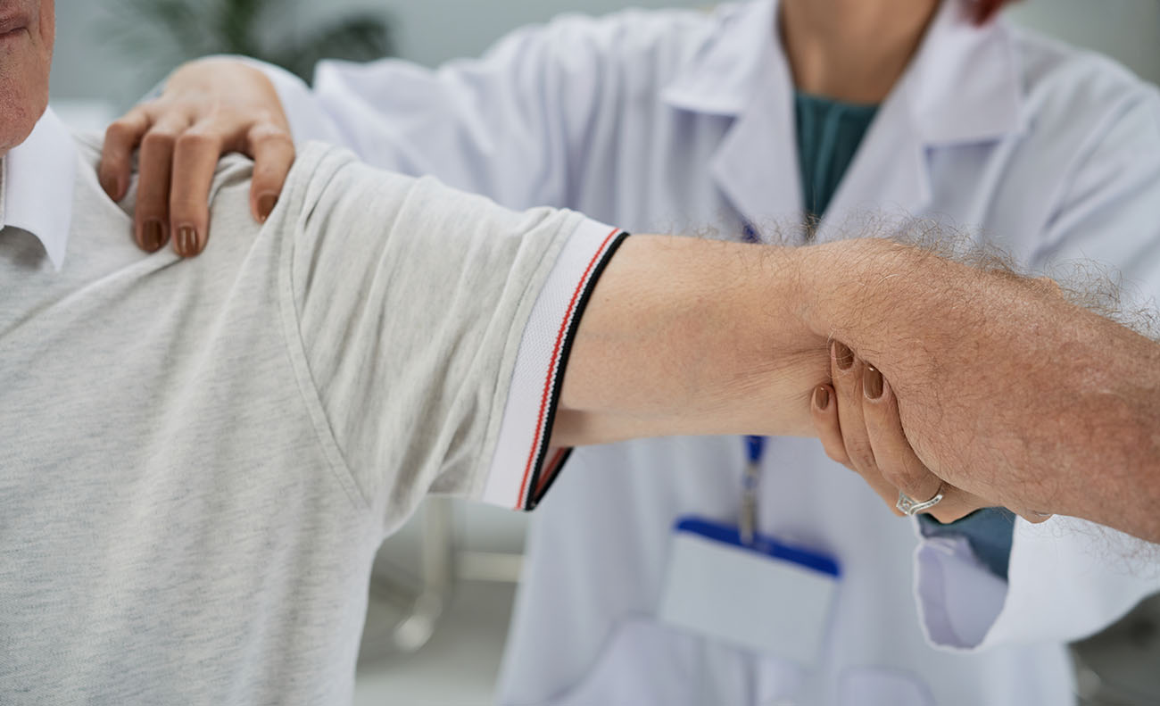 Médico fazendo um tratamento no braço.