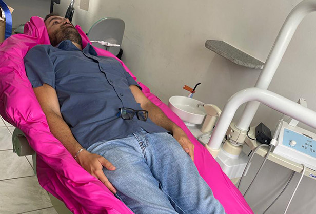 O dentista usa a bomba de vácuo para tirar o restante do ar da câmera interna do posicionador cirúrgico vacuform 2.0 para fixar e moldar no formato personalizado para o paciente.