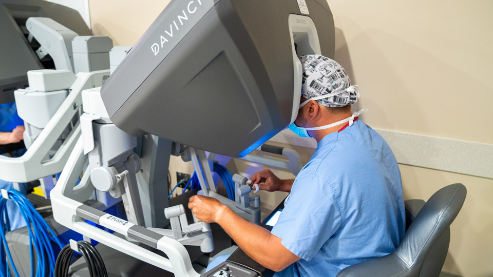 Médico fazendo uma cirurgia com auxílio de um robô.